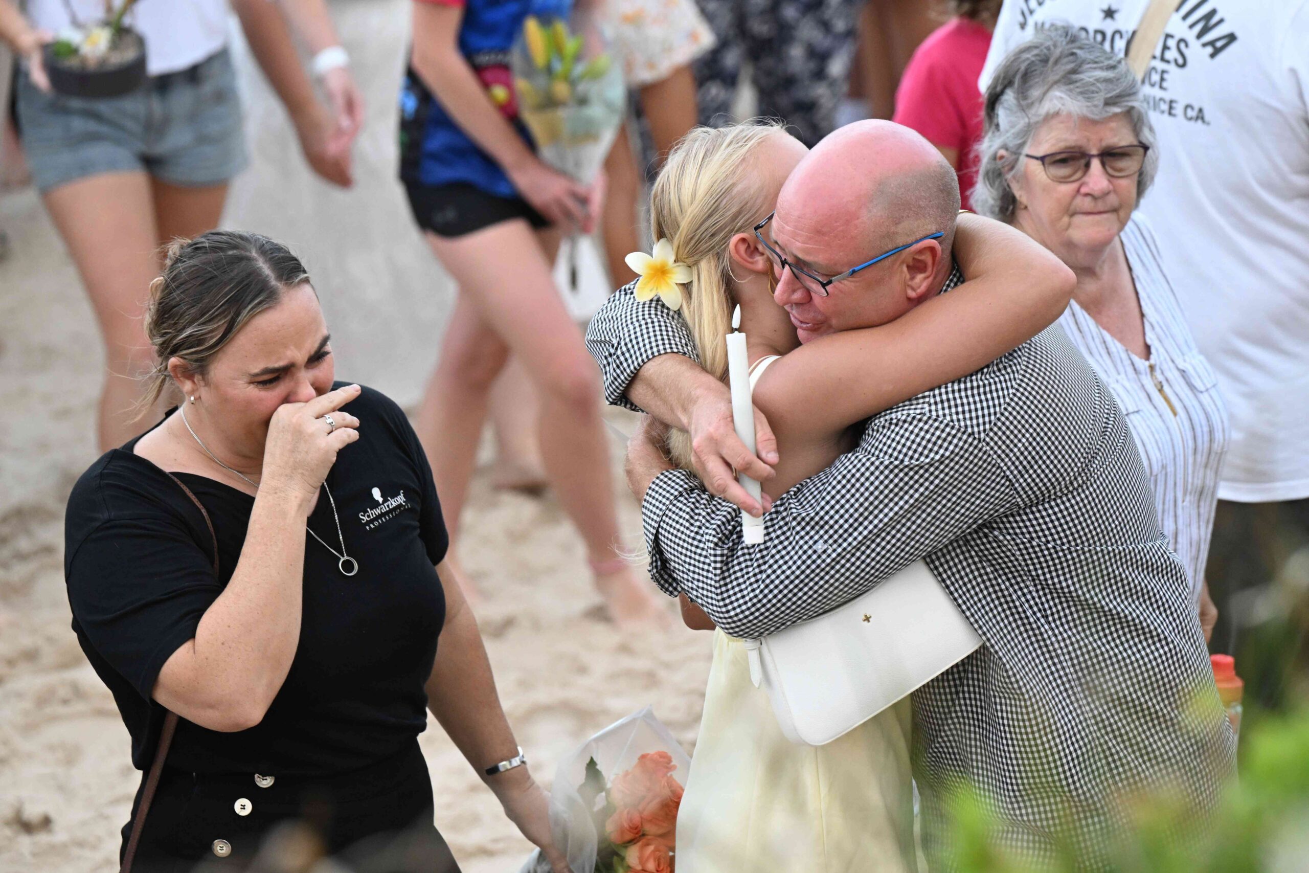 Charlize’s father Steven Zmuda (centre) is seen hugging friends and family during a vigil for his daughter.