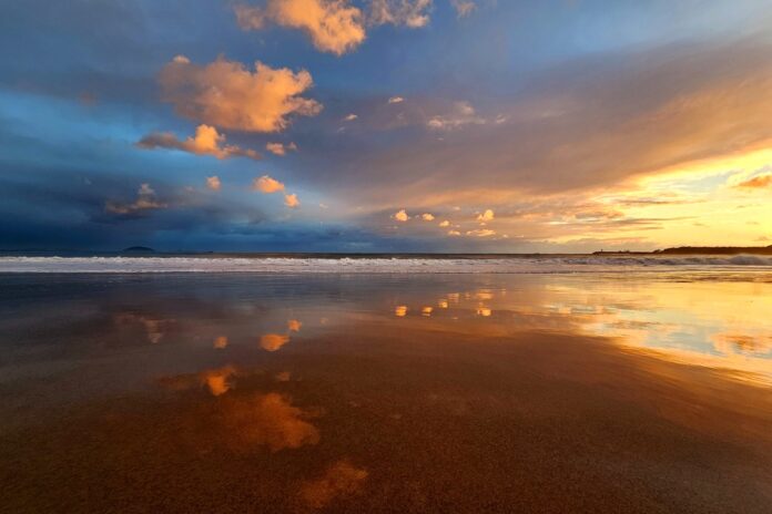 cloud reflections in the sand at dawn at Mooloolaba Beach