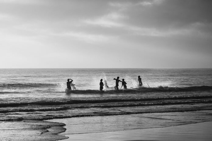 Swimmers at sunrise at Alexandra Headland black and white photo.