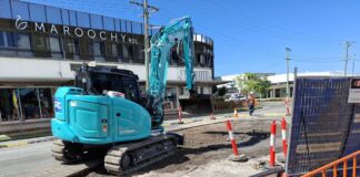 An excavator works on First Avenue.