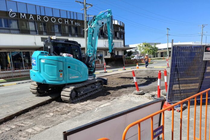 An excavator works on First Avenue.