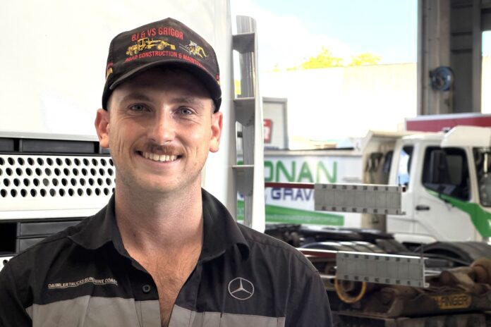 Daniel James, in front of trucks, smiling for the camera.