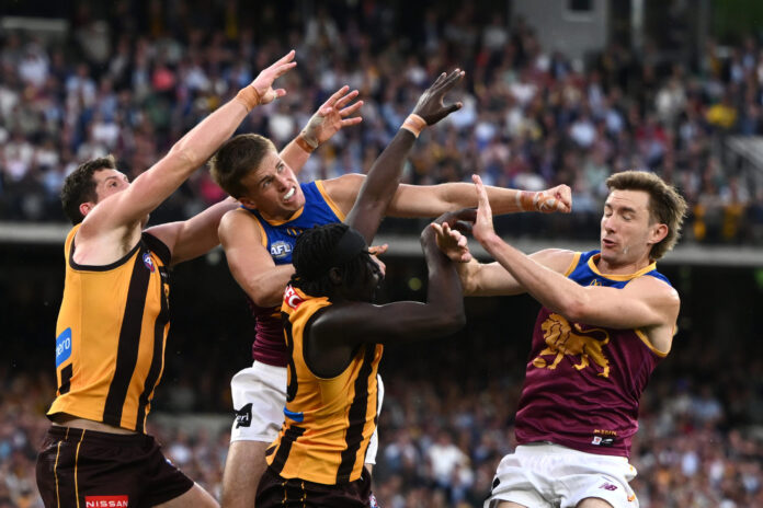 Brisbane Lions player Ty Gallop amid a pack of AFL players competing for the ball.