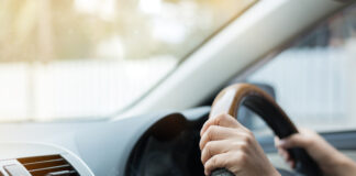 Hands on a steering wheel.