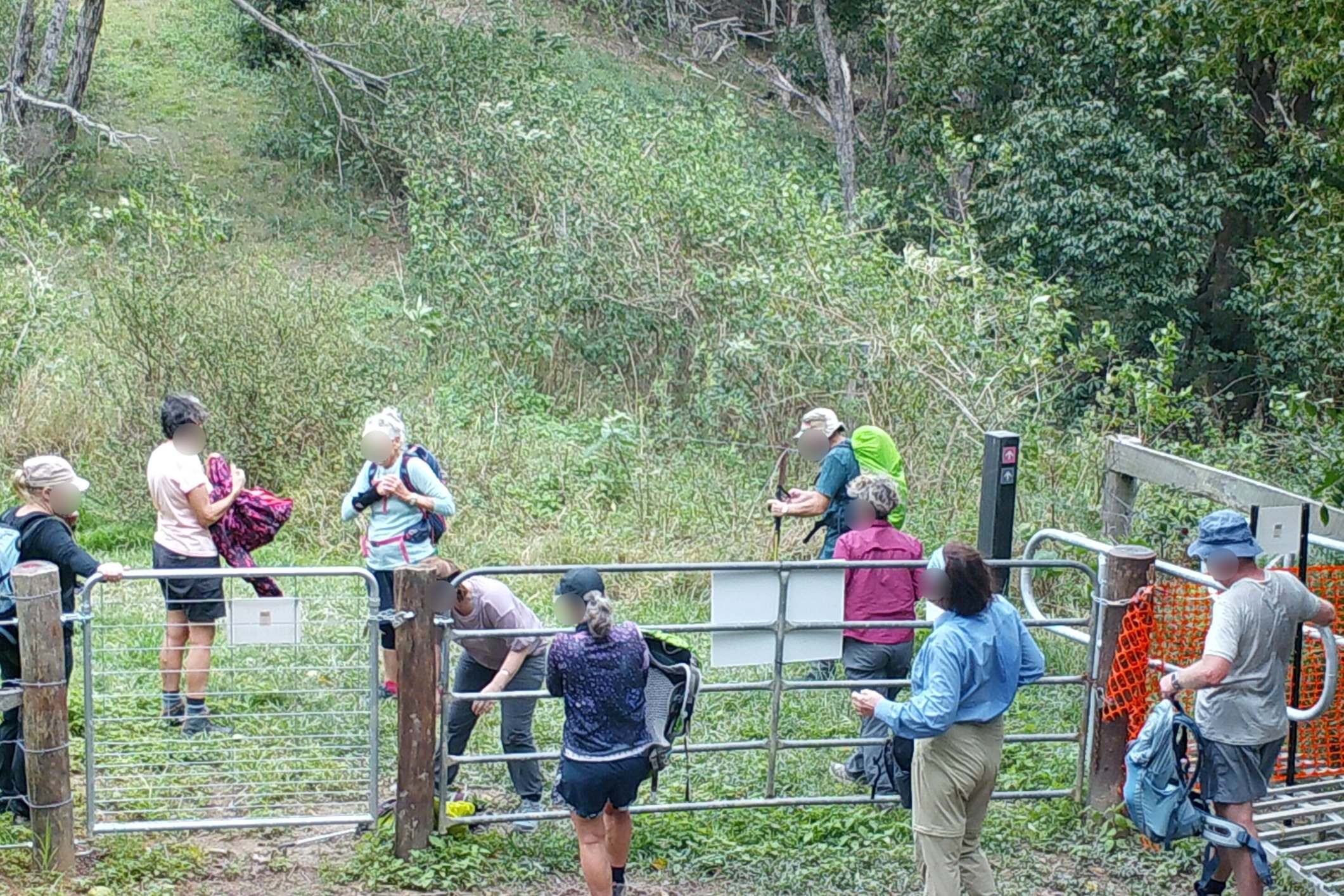 Trail users appear to cross a section of the trail despite closure signs and locked gates.