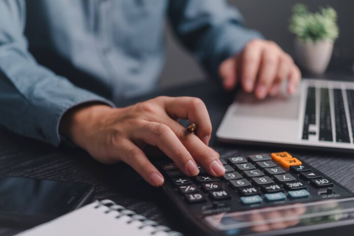 man with calculator shutterstock