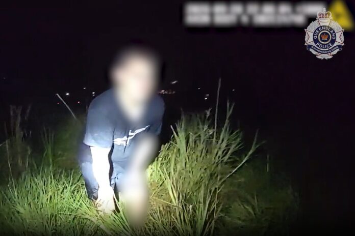 A man being apprehended in long grass.
