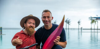 Paralympic swimmer Grant "Scooter" Patterson and Ian Thorpe with the first piece of the Olympic emblem, a reddish curved object about 1m long.