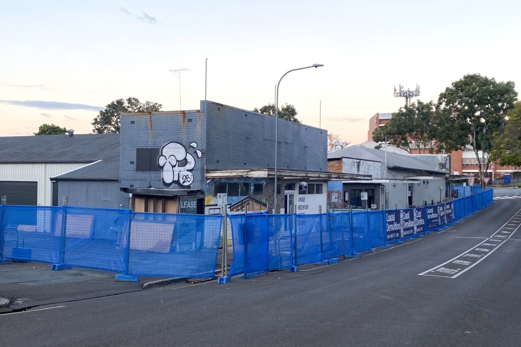 The buildings on the corner of Bury and Currie streets, with demolition fencing around them.