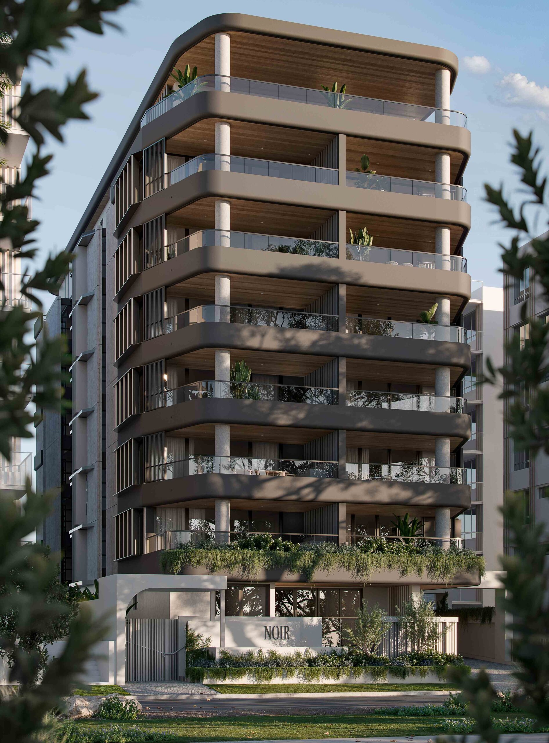 Tall apartment building with glass-fronted balconies, pale exterior walls and landscaped gardens at its entrance.