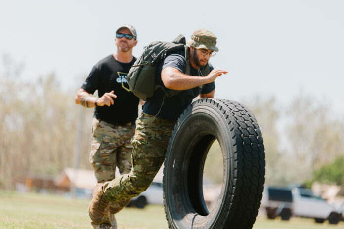 A veteran rolling a large tyre in the heats of the Veteran Games.