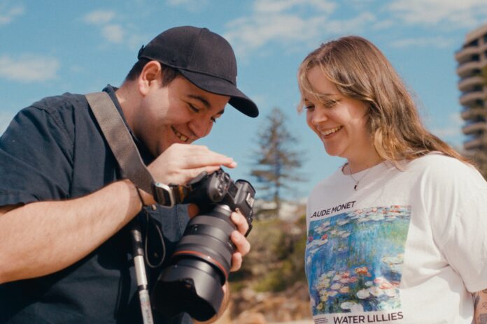James Norquay with his camera on a beach.