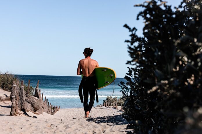 A surfer walking to the water.